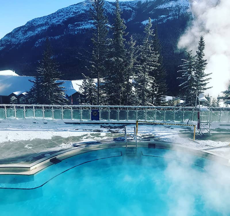 Soak and relax in the Banff Upper Hot Springs with the mountains in the background.