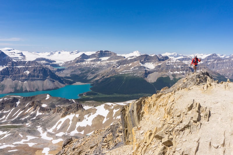 A hiker reaches the summit of Cirque Peak