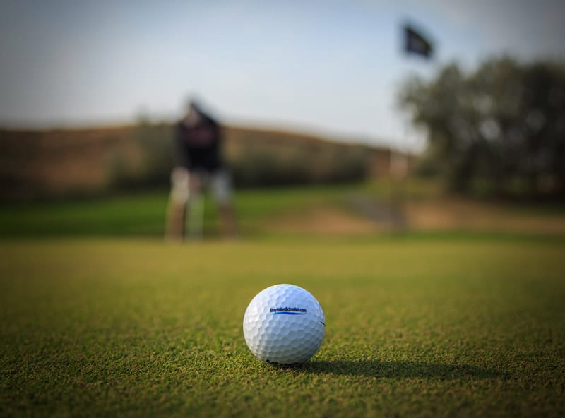 Golf ball and golfer on golf course