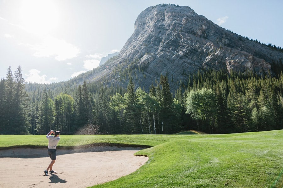 Golfer hits out of the sand bunker at the Fairmont Banff Springs Golf Course