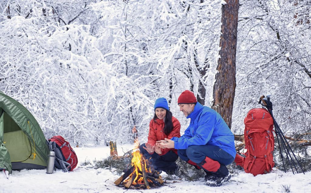 Winter campers around a fire.