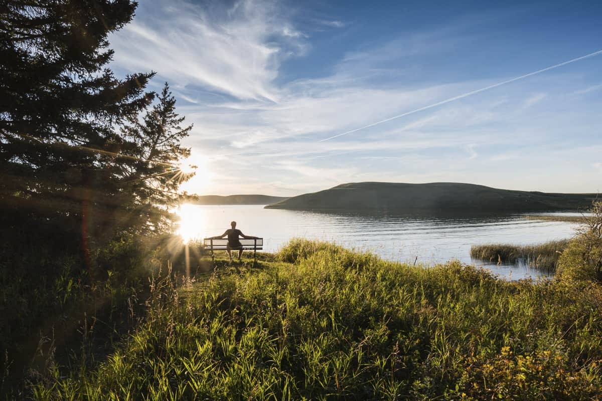 A man sits on the bench at Elkwater Lake in Cypress Hills