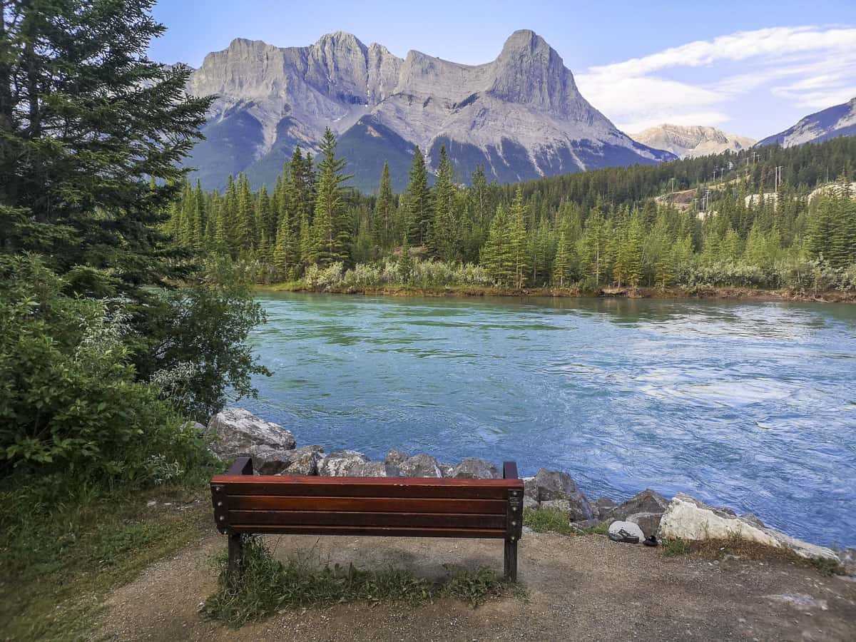 A bench in front of the Bow River in Canmore