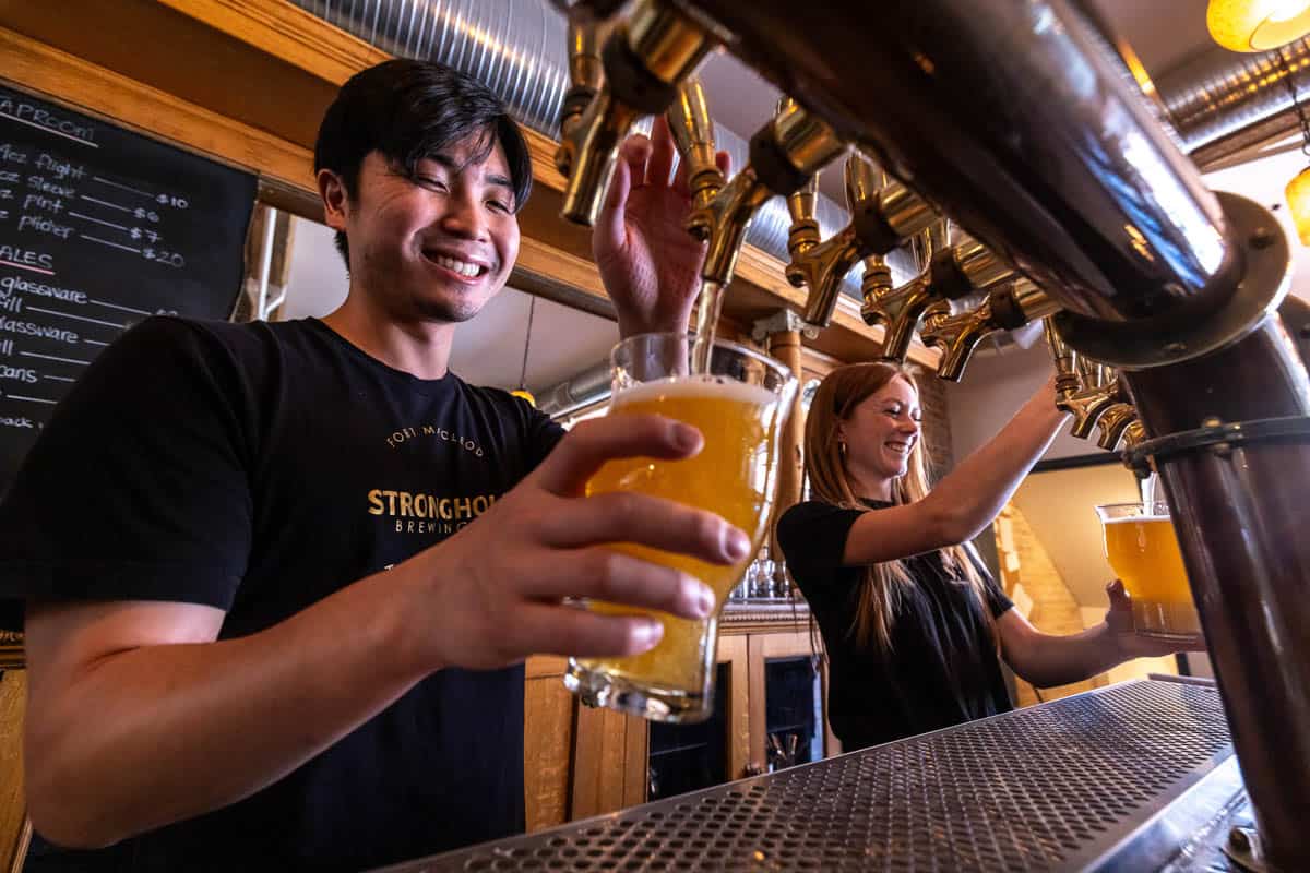 A bartender pouring a beer at Stronghold Brewing
